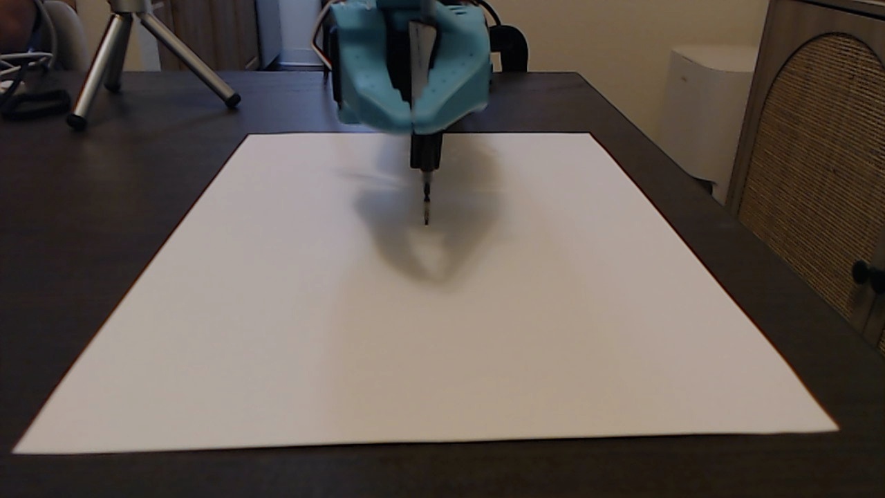 SO101 robot arm holding a pen over a drawing sheet
